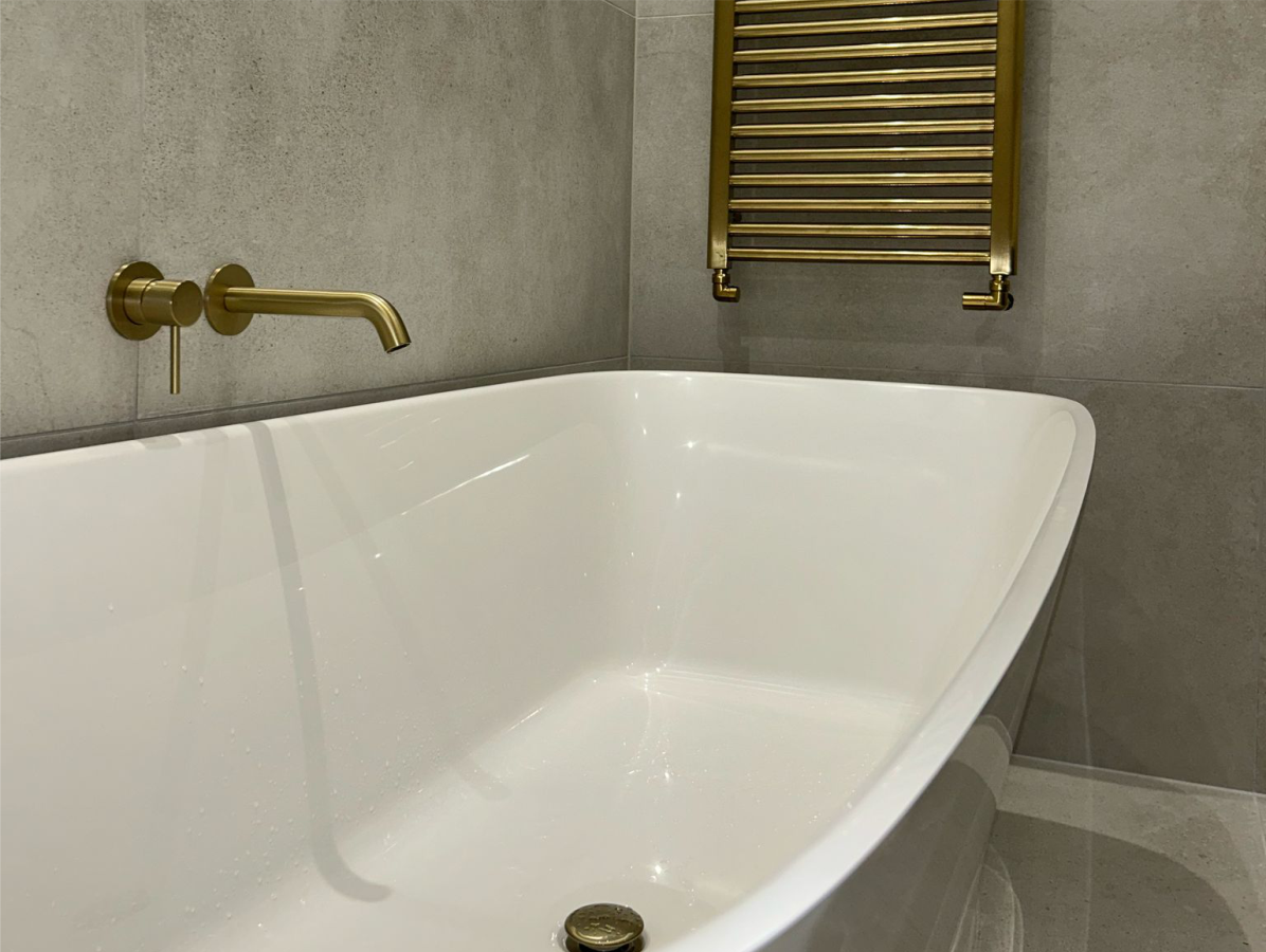 Freestanding bath with gold taps and towel radiator fitted in Romford, Essex