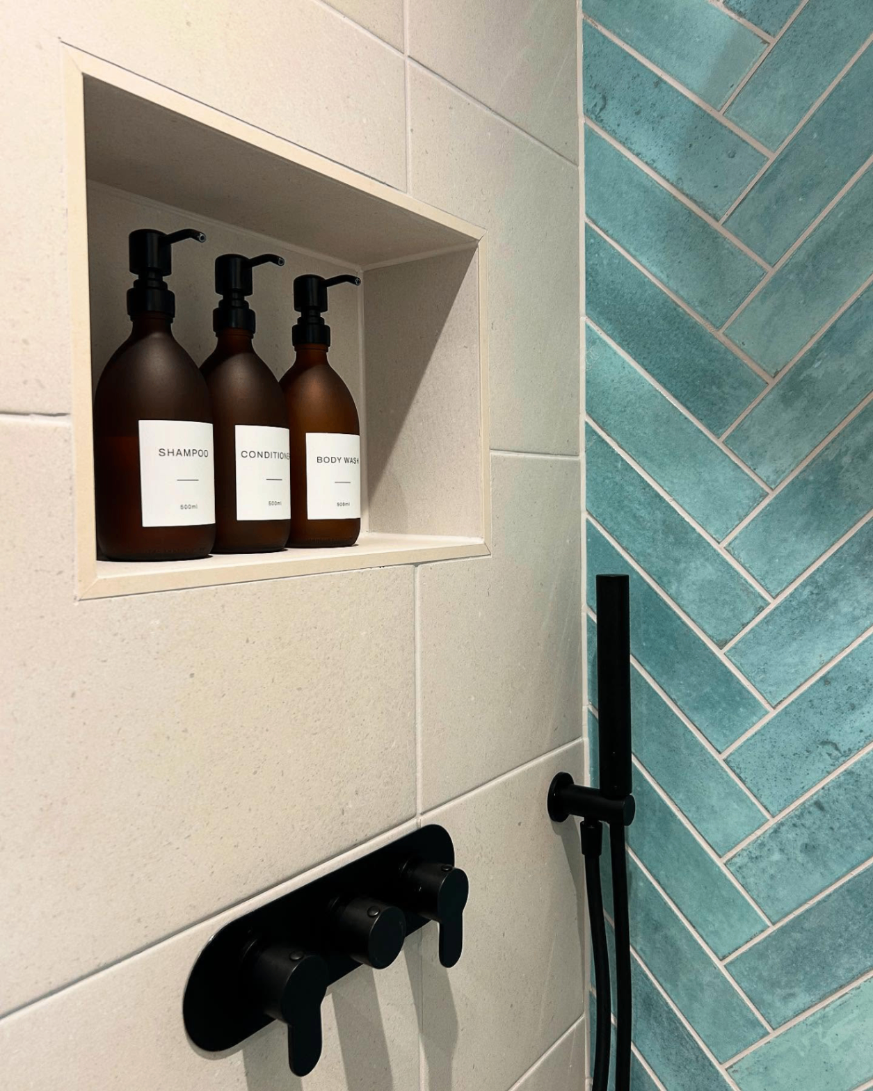 Tiled shower wall shelf with black brassware in Corringham, Essex