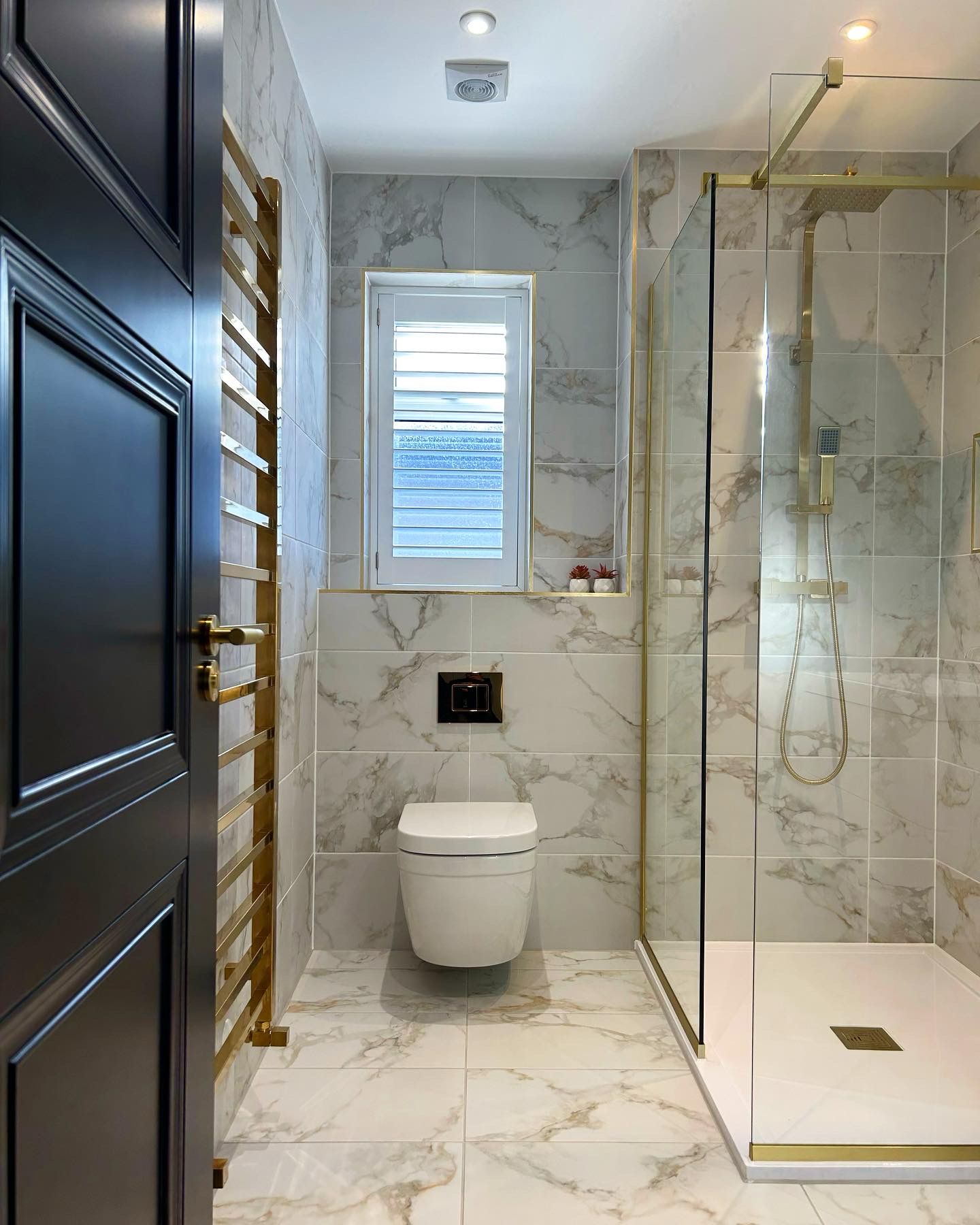 Marble walk in shower with brass fittings in an Essex bathroom renovation
