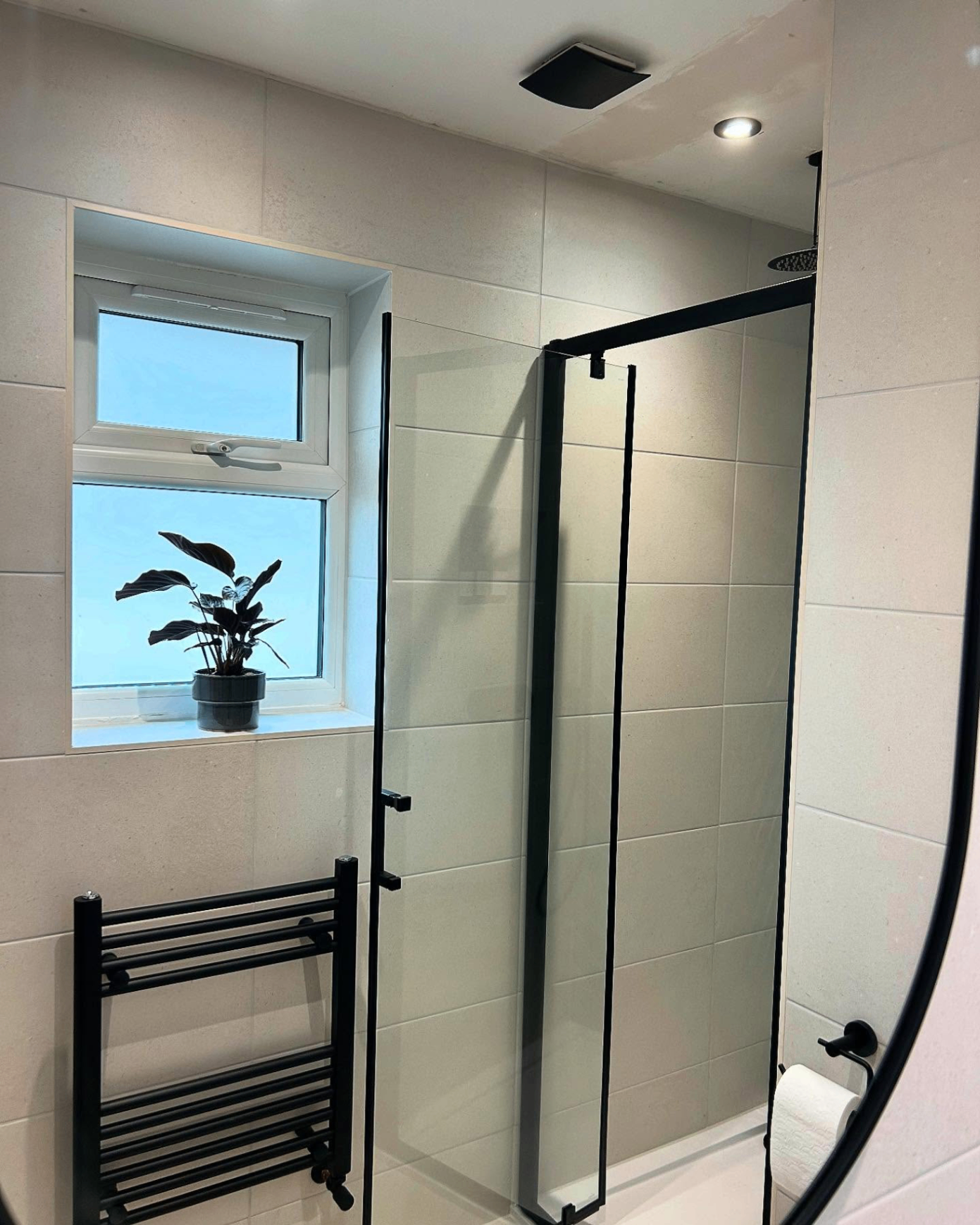 Shower door and black heated towel radiator in a Corringham bathroom, Essex